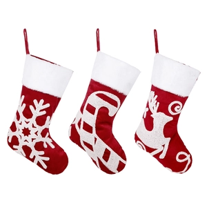 Three Christmas stockings with embroidered reindeer and snowflake on white background