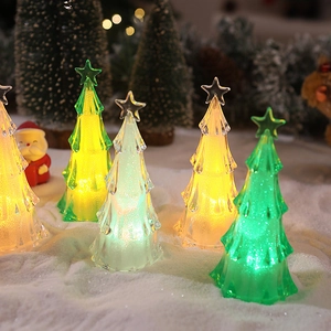 Macro shot of colorful LED acrylic Christmas tree lights with starry toppers on faux snow