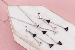 Close-up of geometric triangle tassel necklace and earrings set in silver stainless steel