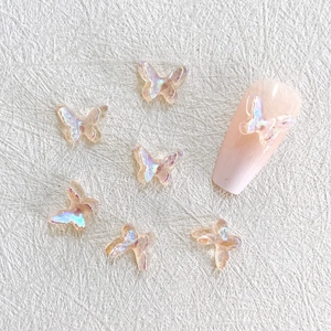 Macro shot of 3D iridescent resin butterfly charms on a pink manicured fingernail
