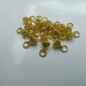 Bulk lot of golden lotus pod charms for DIY jewelry making on white background