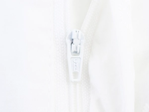 Macro detail of white metal zipper slider with embossed letters on wide leg trousers