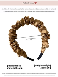 Detailed view of the pleated satin headband in bronze gold with smooth silk luster