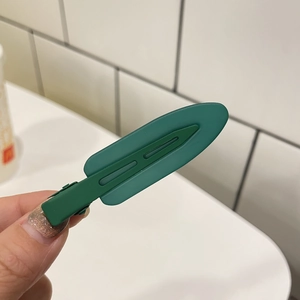 Detail of dark green matte jelly hair clip with duckbill design for styling