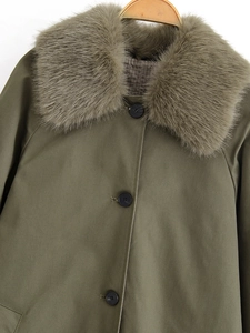 Detailed view of olive green trench coat featuring a detachable faux fur collar and buttons