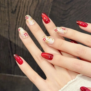 Elegant red and white floral press-on nails with gold leaf details on oval shape nails