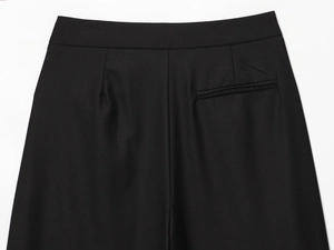 Détail du pantalon en sergé noir montrant la taille et les finitions de la poche arrière