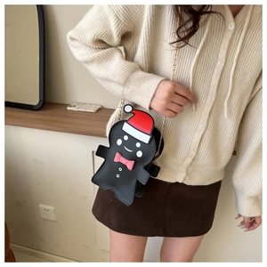 Detail of gingerbread man crossbody bag with gold chain strap on a beige sweater