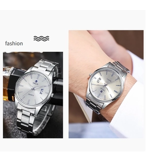 Macro detail of silver stainless steel business watch featuring date window and steel strap