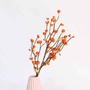 Detail of faux orange berries in a ribbed ceramic vase for harvest home decor