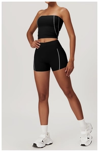 Detail of black yoga set featuring white contrast stitching on sports top and shorts