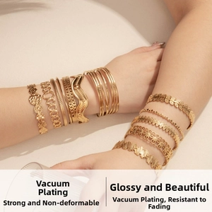 Detailed close-up of stacked gold-plated snake and geometric textured cuff bracelets