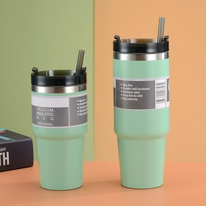 Detail showing two light green 32oz vacuum insulated stainless steel mugs with straws
