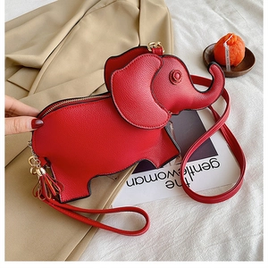Detailed top view of red elephant-shaped bag with tassel and litchi texture on blazer