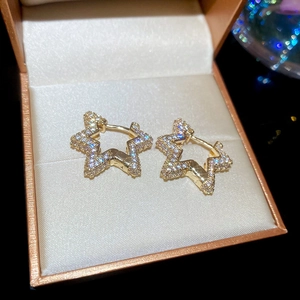 Close-up of gold zircon star hoop earrings presented in a luxury brown jewelry gift box