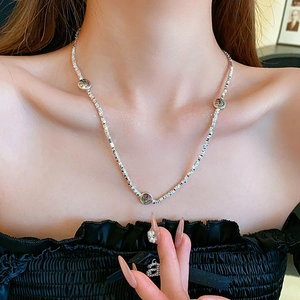 Close-up of a silver smiling face pendant necklace worn on a model's neck