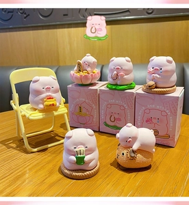 Detailed view of zen-style pink pig resin figurines with individual gift packaging