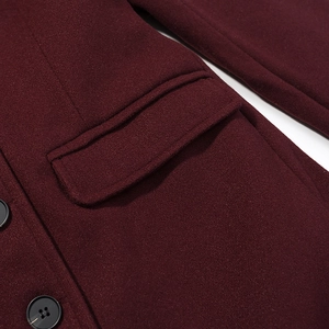 Close-up of deep red wool coat showing fabric texture, black buttons and pocket flap