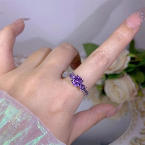 Fashionable silver-finish ring with three purple zircon stones on female finger