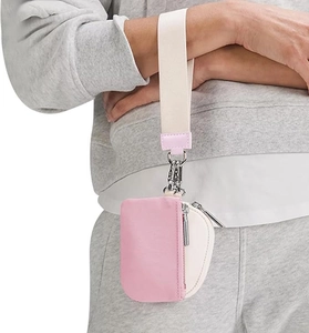 Detail view of pink and beige mini wristlet pouch with metal zipper and wrist strap