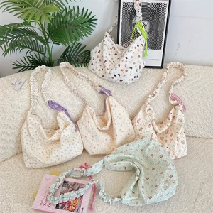 Detail of quilted canvas underarm bags with cartoon patterns and scrunchie straps