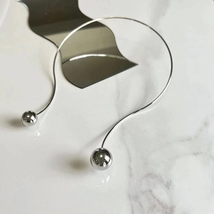 Λεπτομέρεια ασημένιο choker με μεταλλικές σφαίρες σε μάρμαρο και επιφάνεια καθρέφτη