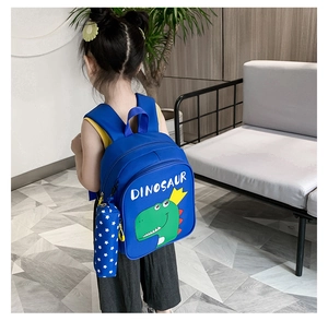 Blue dinosaur backpack with matching pencil case for kids shown in a cozy home setting