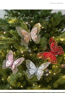 Close-up of sequined mesh feather butterfly ornaments with pearls on a Christmas tree