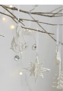 Close-up of silver glitter Christmas ornaments with treble clef and star hanging on branches