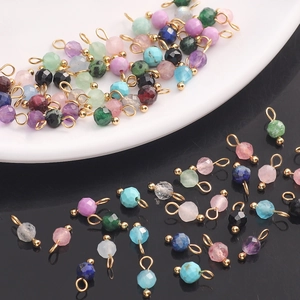 Detailed macro view of multi-colored faceted natural stone pendants with gold metal loops