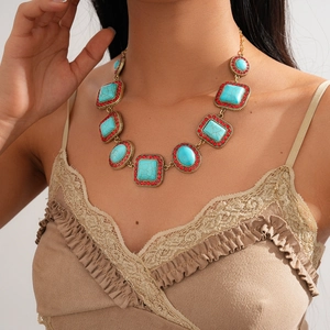 Detail of bohemian gold choker with green turquoise stones and red rhinestone inlay