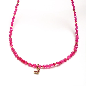 Close-up of bohemian beaded necklace with pink agate beads and sparkling heart pendant