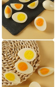 Realistic PVC boiled egg models showing sliced textures and yolks on a woven mat