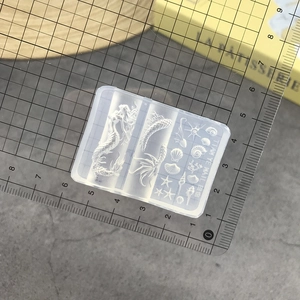 Detailed view of clear silicone mermaid and sea shell nail art mold with scale ruler