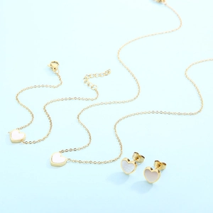 Golden stainless steel jewelry set with white shell heart necklace, bracelet, and earrings
