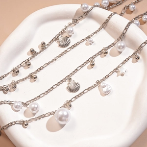 Detail of silver layered waist chain with pearls, shell pendants and star charms