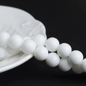Macro shot of smooth white round sunstone beads for DIY jewelry making and craft projects