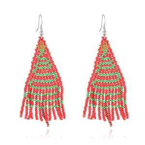 Detail of handmade beaded Christmas tree earrings with colorful tassels and gold hooks