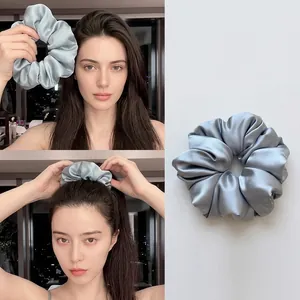 Detailed view of soft silk scrunchie for hair protection during sleep in silver grey