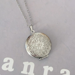 Vintage stainless steel locket necklace with floral relief and circular openable pendant