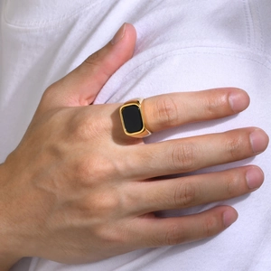 Close-up of a gold stainless steel signet ring with a black rectangular stone insert