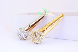 Close-up of gold and silver microphone keychains featuring sparkling rhinestone details