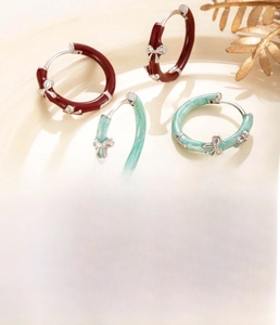 Macro shot of 15mm copper enamel bow earrings set in red and mint green silver-tone finish