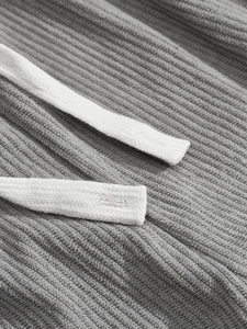 Macro detail of grey ribbed fabric texture and white braided drawstring on men's leisure set