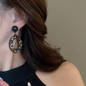 Gros plan d'un mannequin portant des boucles d'oreilles léopard au style automnal chaud