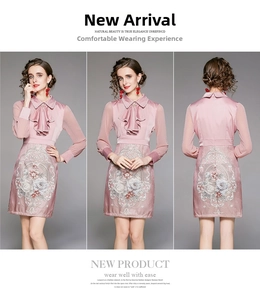 Detailed view of pink vintage dress featuring intricate floral embroidery and satin finish