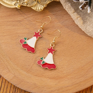 Detail view of festive Christmas hat earrings with red star and gold hooks on wooden tray