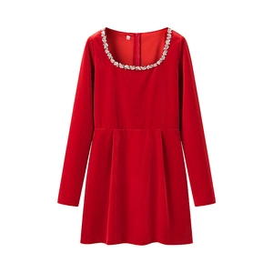 Close-up of red velvet dress neckline featuring intricate rhinestone and sequin details