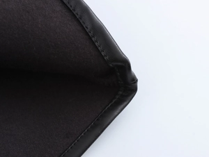 Close-up of high-quality stitching detail on a black biker-style maxi dress fabric