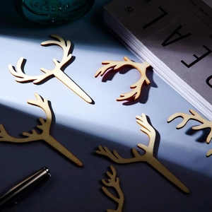 Artistic top view of six wooden reindeer antler cupcake toppers on a blue surface